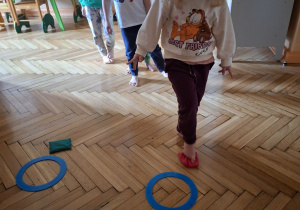 Na tym zdjęciu wdać dzieci z grupy II wykonujące ćwiczenia stóp z wykorzystaniem woreczka.