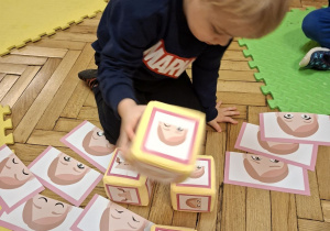 Na tym zdjęciu widać Mikołaja L. rzucającego kostką podczas gry "Minki".