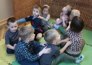 Zdjęcie przedstawia dzieci z grupy III podczas zabawy relaksacyjnej "Masażyki".