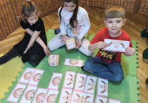 Zdjęcie przedstawia Filipa z grupy IV wraz z dwiema koleżankami grających w grę "Minki".