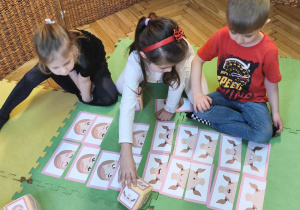 Zdjęcie przedstawia Filipa z grupy IV wraz z dwiema koleżankami grających w grę "Minki".