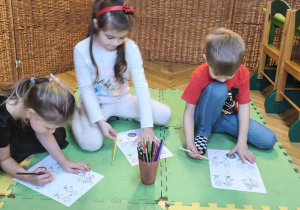 Na tym zdjęciu widać Alę R., Marcelinę Ł. oraz Filipa z grupy IV wykonujących kartę pracy "Nasze emocje".