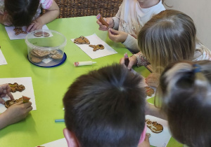 Na tym zdjęciu widać kilkoro dzieci z grupy IV ozdabiających pierniczki.