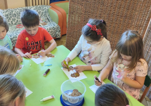 Na tym zdjęciu widać kilkoro dzieci z grupy IV ozdabiających pierniczki.