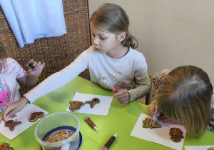 Zdjęcie przedstawia Kalinę,Klarę J. i Wandę, które ozdabiają pierniczki.