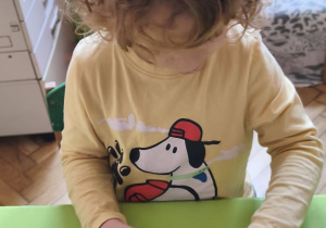 Na tym zdjęciu widać Mikołaja z grupy III ozdabiającego lukrem wefelek ryżowy, tworząc bombkę