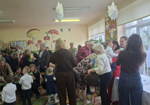 Zdjęcie przedstawia niektóre dzieci wręczające swoim bliskim upominki.