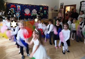 Na tym zdjęciu widać dzieci wykonujące układ taneczny z chustkami.