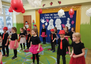 Zdjęcie przedstawia dzieci wykonujące układ taneczny.