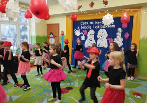 Zdjęcie przedstawia dzieci wykonujące układ taneczny.