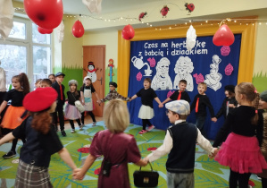 Zdjęcie przedstawia dzieci wykonujące układ taneczny.