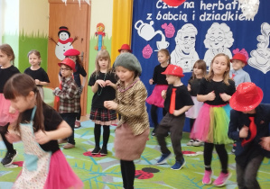 Zdjęcie przedstawia dzieci wykonujące układ taneczny.