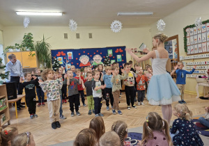 Na tym zdjęcu widać chłopców ćwiczących elementy tańca baletowego pod okiem jednej z tancerek.