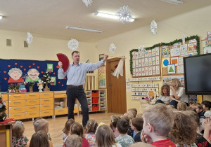 Zdjęcie przedstawia prowadzacego pokaz, który prezentuje dzieciom rekwizyty z przedstawień baletowych.