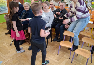 Na tym zdjęciu widać dzieci wręczające Seniorom upominki.