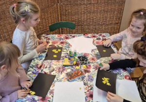 Zdjęcie przedstawia cztery dziewczynki wykonujące kolejną pracę w ramach zajęć z edukacji przez ruch.