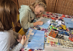 Zdjęcie przedstawia dwie dziewczynki wykonujące kolejną pracę w ramach zajęć z edukacji przez ruch