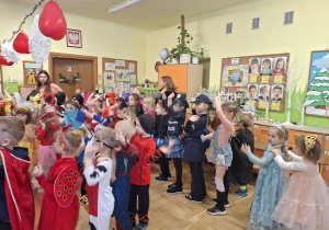 Na tym zdjęciu widać dzieci biorące udział w zabawach karnawałowych przy muzyce.