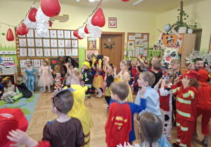 Na tym zdjęciu widać dzieci biorące udział w zabawach karnawałowych przy muzyce.