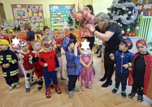 Na tym zdjęciu widać dzieci biorące udział w zabawach karnawałowych przy muzyce.