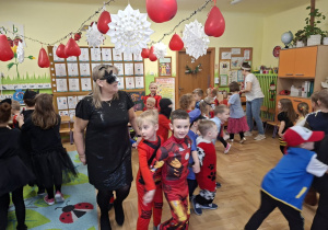 Na tym zdjęciu widać dzieci biorące udział w zabawach karnawałowych przy muzyce.