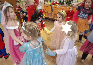 Na tym zdjęciu widać cztery dziewczynki z grupy I oraz kilkoro dzieci z grupy IV podczas zabawy karnawałowej.