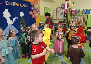Zdjęcie przedstawia dzieci z grupy II wraz z nauczycielką podczas zabawy karnawałowej.