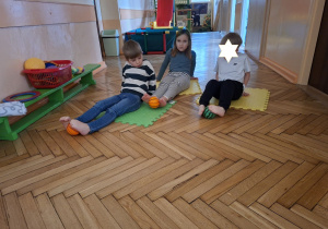 Na tym zdjęciu widać Filpa, Klarę P. oraz Fabiana z grupy IV, uczestników projektu wykonujących ćwiczenia przeciw płaskostopiu z piłką.