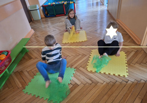 Na tym zdjęciu widać Filpa, Klarę P. oraz Fabiana z grupy IV, uczestników projektu wykonujących ćwiczenia przeciw płaskostopiu z chustkami.