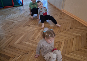 Zdjęcie przedstawia Jagodę, Maksa i Kubę S. z grupy II wykonujących ćwiczenia wiloznaczne, ogólnorozwojowe.