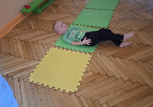 Na tym zdjeciu widać Kubę S. z grupy II wykonującego ćwiczenie wspomagające rozwój fizyczny, wzmacniające mięśnie głębokie tułowia, brzucha i szyi.