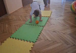 Zdjęcie przedstawia Maksa z grupy II wykonującego ćwiczenie rozwijające koordynację wzrokowo-ruchową.