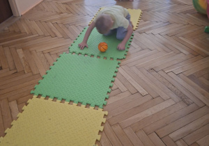 Zdjęcie przedstawia Kubę S. z grupy II wykonującego ćwiczenie rozwijające koordynację wzrokowo-ruchową.