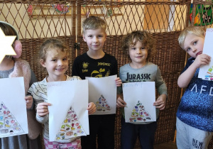 Na tym zdjęciu pięcioro dzieci z grupy III prezntuje wykonane przez siebie piramidy zdrowego żywienia.