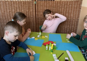 Zdjęcie przedstawia czworo dzieci podczas wykonywania pracy.