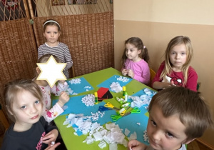 Zdjęcie przedstawia czworo dzieci podczas wykonywania pracy.