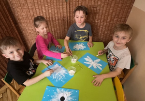 Zdjęcie przedstawia czworo dzieci podczas wykonywania pracy.