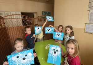 Zdjęcie przedstawia kilkoro dzieci prezentujących gotowe prace - misie polarne.