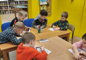 Na tym zdjęciu widać dzieci kolorujące malowanki.