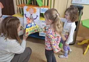 Zdjęcie przedstawia panią dyrektor oraz Krysię i Marcelinkę oglądające jedną z prac konkursowych.