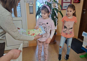 Zdjęcie przedstawia panią dyrektor wręczjącą nagrodę Marcelinie Ł. za udział w konkursie.