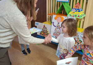 Zdjęcie przedstawia panią dyrektor wręczjącą nagrodę Krysi P. i Marcelinie R-K. za udział w konkursie.