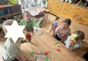 Na tym zdjęciu widać czworo dzieci prezentujące wykonane przez siebie klauny.