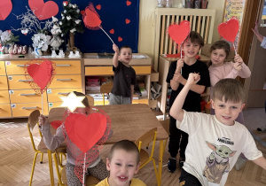 Na tym zdjęciu widać dzieci, które prezentują wykonane przez siebie serca.