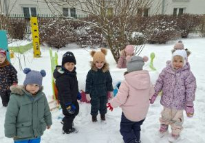Zdjęcie przedstawia dzieci podczas zimowych zabaw w ogrodzie.
