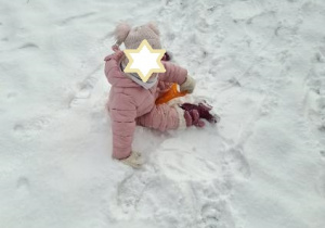 Zdjęcie przedstawia jedną z dziewczynek zjeżdżającą z górki na jabłuszku.