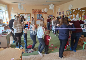 Zdjęcie przedstawia rodziców i dzieci podczas wspólnych zabaw przy muzyce.