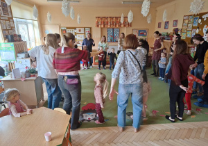 Zdjęcie przedstawia rodziców i dzieci podczas wspólnych zabaw przy muzyce.