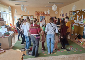 Zdjęcie przedstawia rodziców i dzieci podczas wspólnych zabaw przy muzyce.