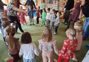 Zdjęcie przedstawia rodziców i dzieci podczas wspólnych zabaw przy muzyce.